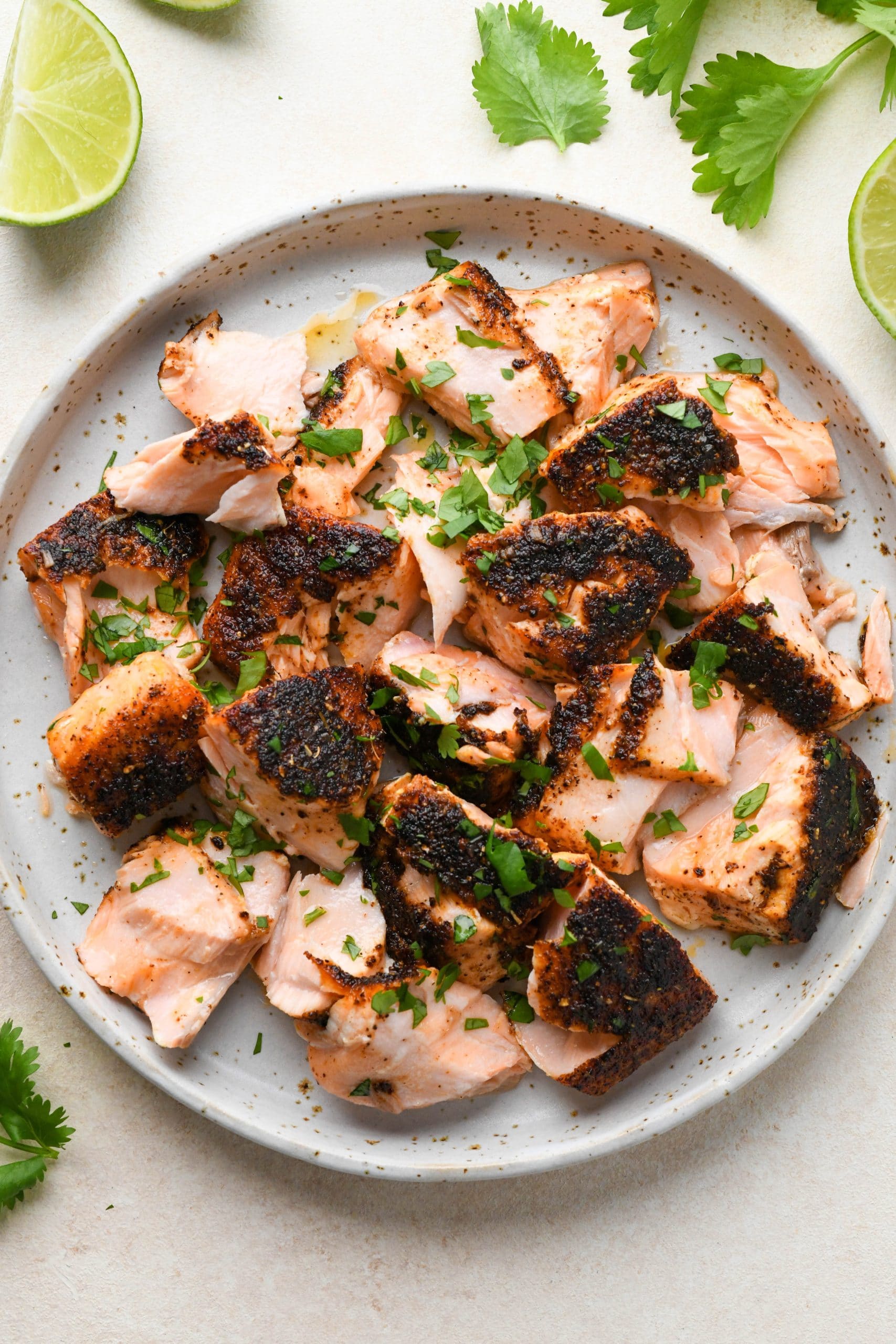 How to make blackened salmon tacos: Cooked salmon flaked on a plate.