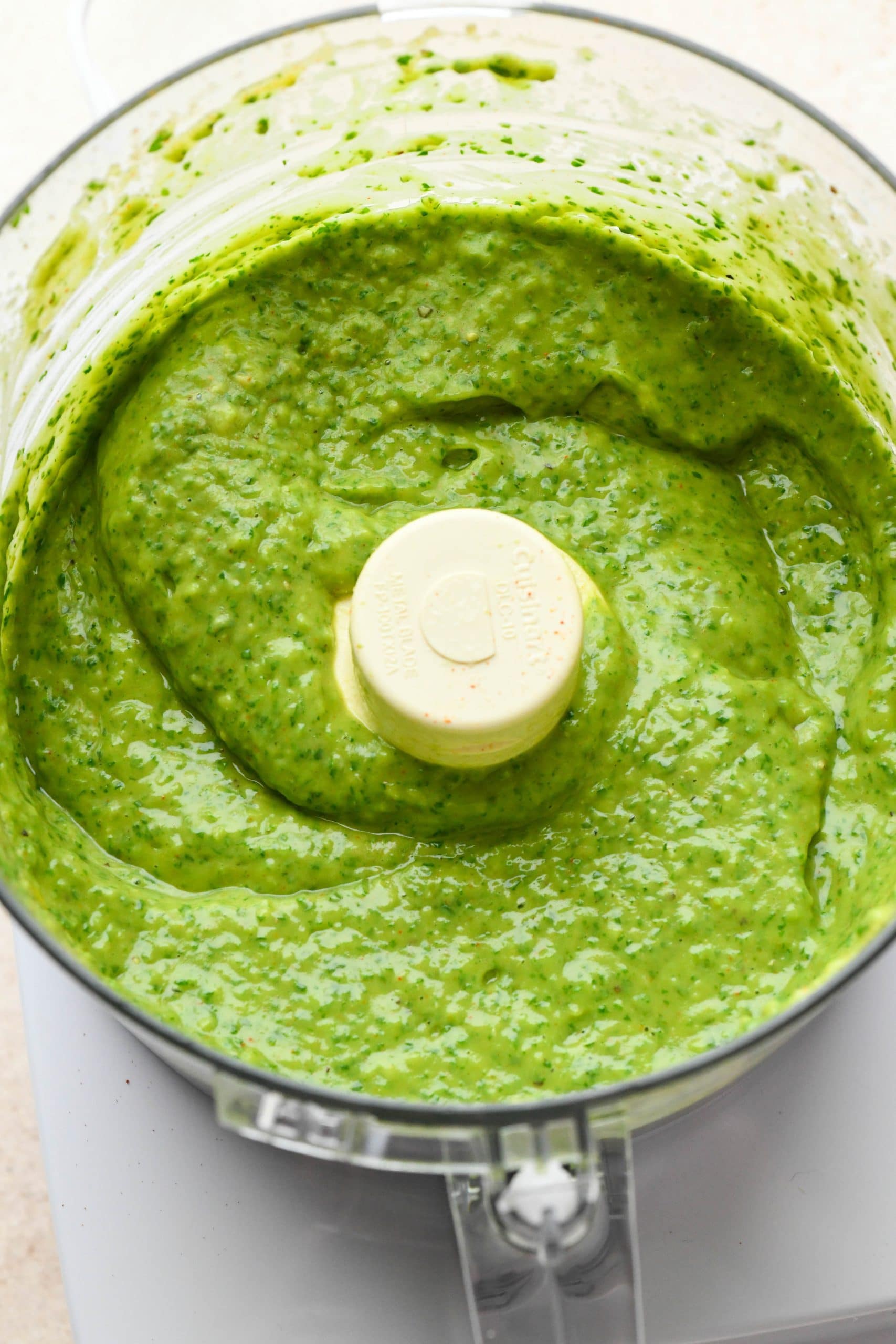 How to make avocado herb green sauce: Sauce processed together in the bowl of a food processor. 