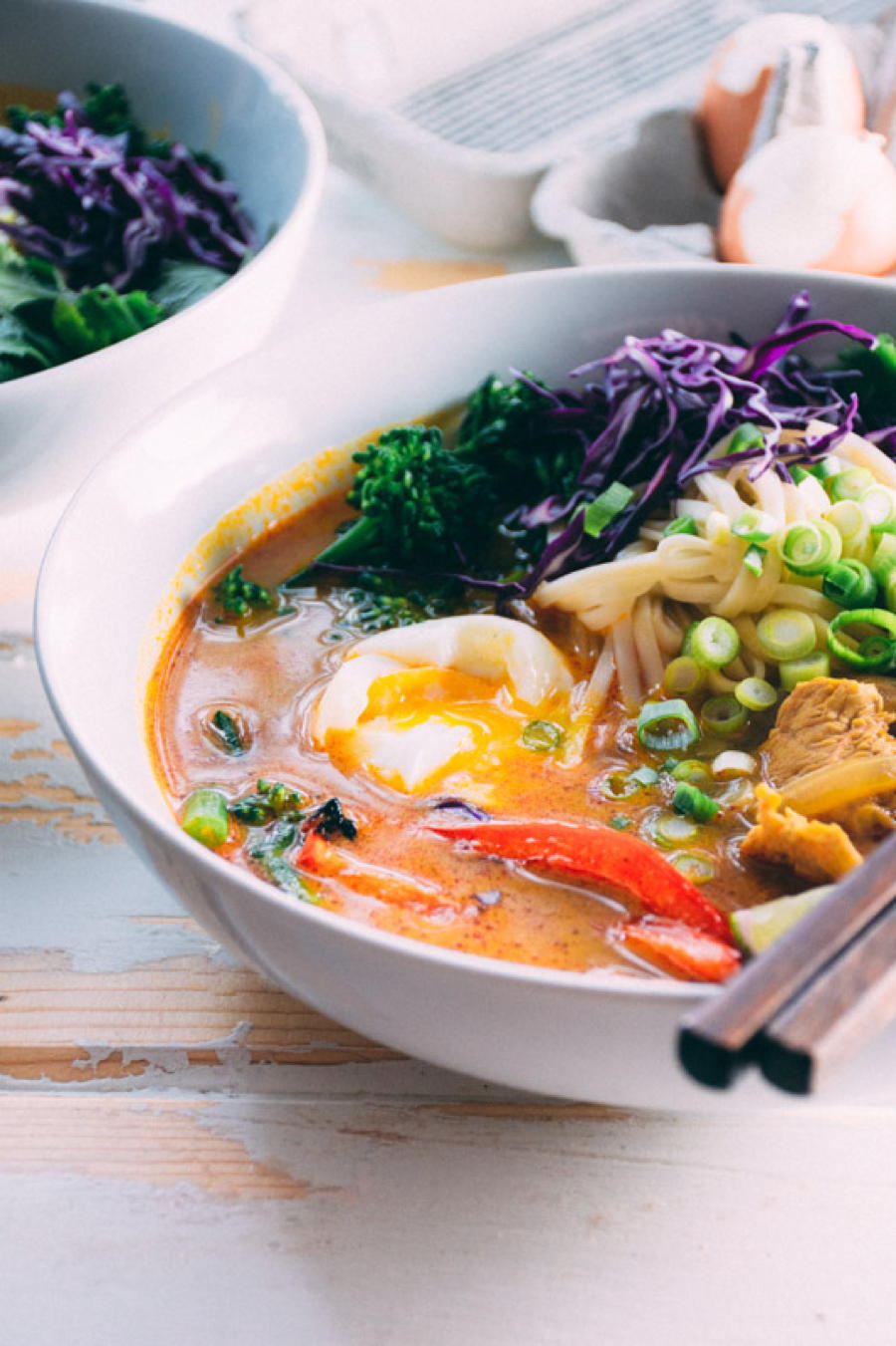 a satisfying and easy curry noodle soup made with chicken, udon noodles, red curry paste, garlic, ginger, turmeric, onions, red peppers, broccolini, soft boiled eggs and finished with cilantro, green onions and shredded red cabbage. | www.nyssaskitchen.com