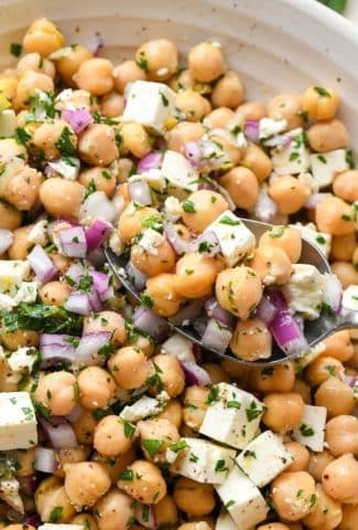 A spoon scooping up some lemony chickpea feta salad.