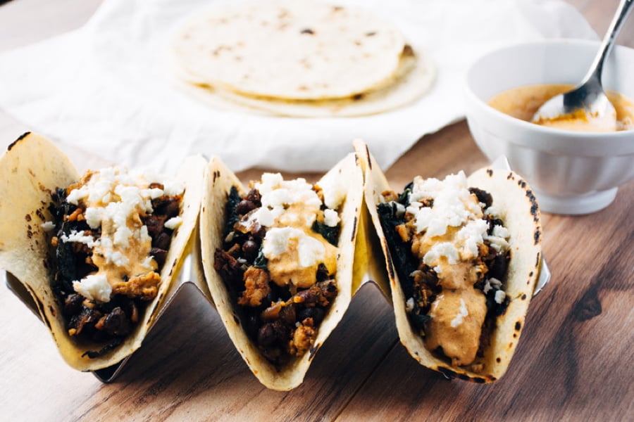 a quick and healthy recipe for chicken tacos with black beans, kale, romesco yogurt sauce and feta cheese. | www.nyssaskitchen.com