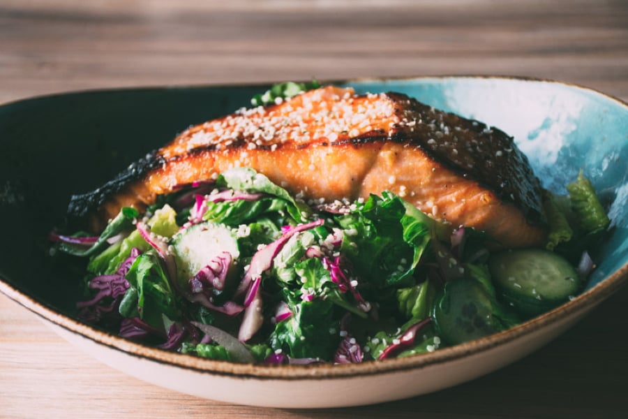 a mega healthy and flavorful recipe for garlicky miso marinated salmon with a big salad of fresh romaine and arugula, cucumbers, red cabbage and a lime and olive oil vinaigrette | www.nyssaskitchen.com