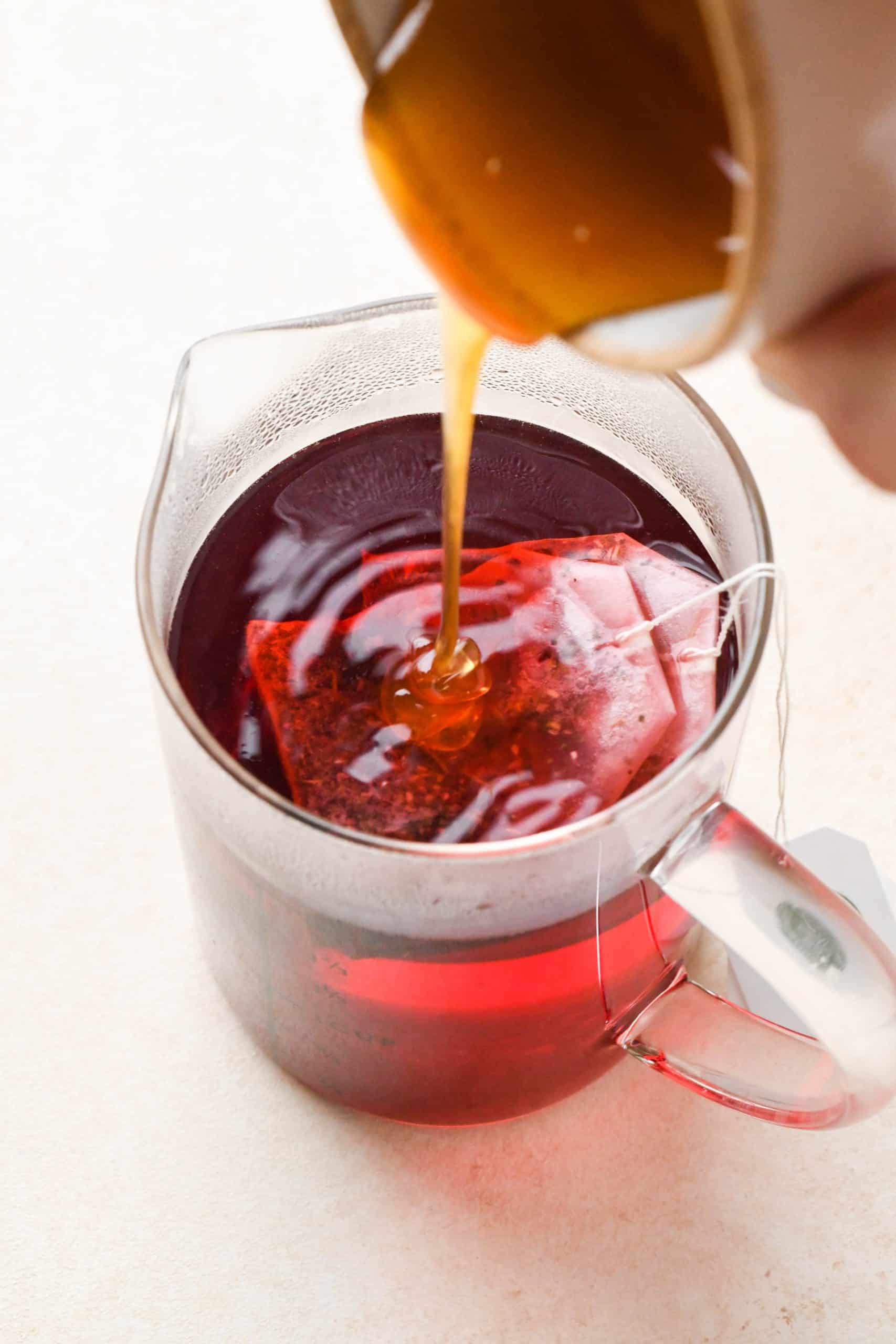 How to make Strawberry Hibiscus Slushies: Pouring honey into hot hibiscus tea.