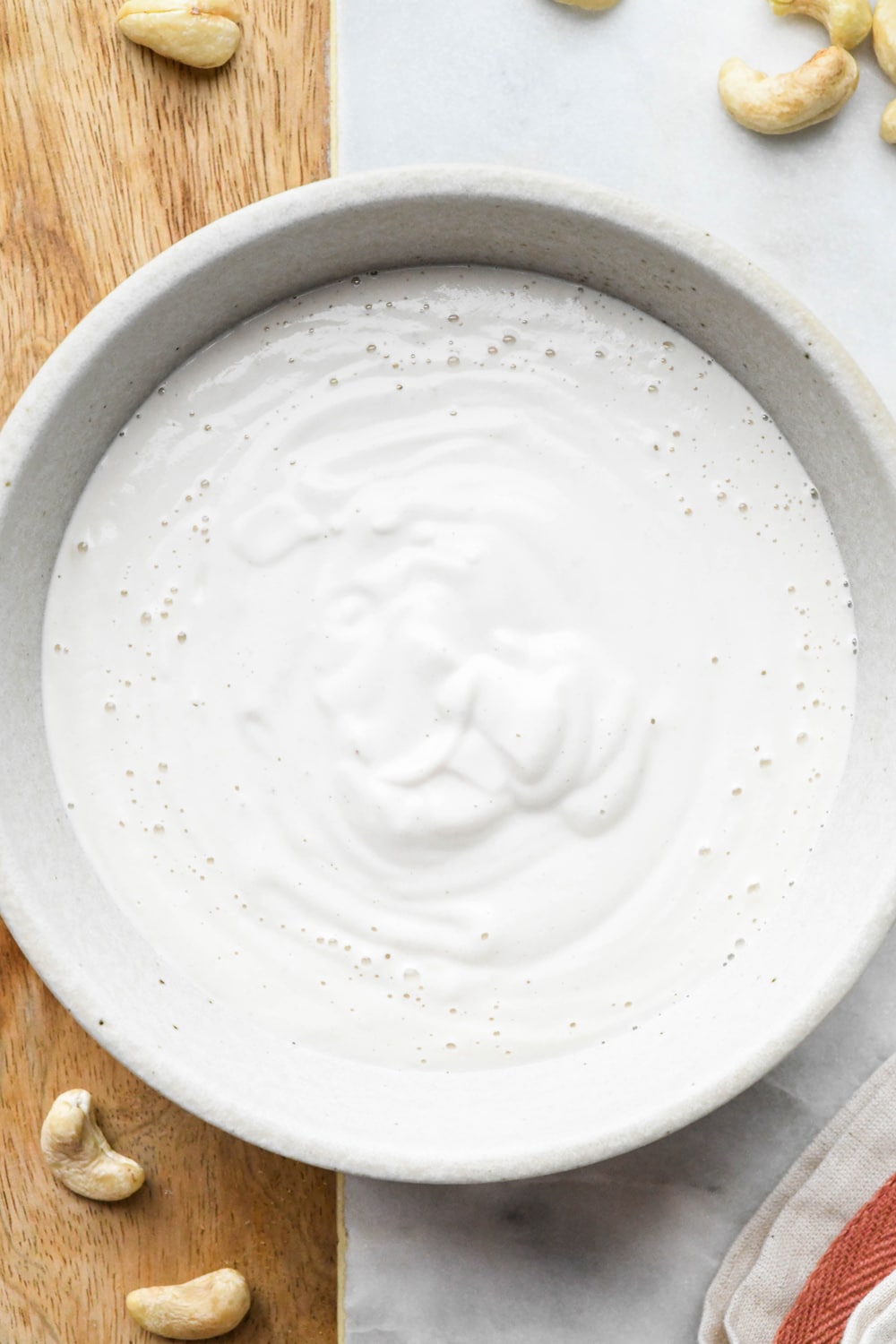A grey ceramic bowl filled with cashew cream made with 3/4 cup water.