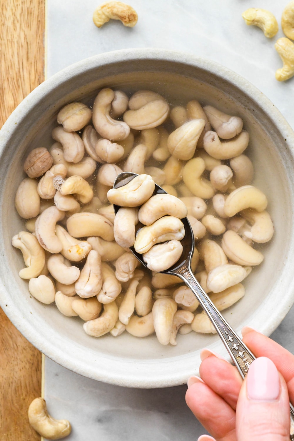 How to make cashew cream: Raw cashews in a bowl of water after soaking - cashews are pale in color and plump.