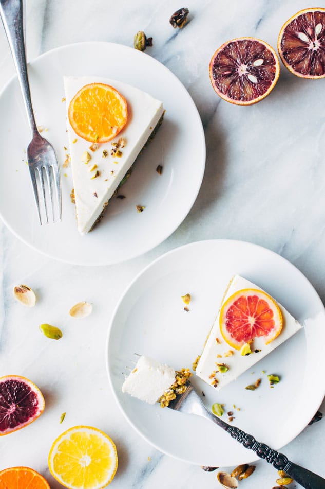 Blood orange and cardamom pistachio no bake greek yogurt cheesecake! A delightful + healthy gluten free dessert that will satisfy your cheesecake loving sweet tooth. Made with greek yogurt, coconut, blood oranges, vanilla, a date-sweetened pistachio crust and topped with fresh citrus and cardamom candied pistachios.
