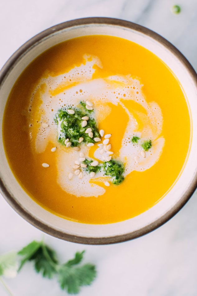 Thai carrot and sweet pepper coconut soup with cilantro pesto - The perfect, vibrant, veggie packed soup for your midwinter cravings! It's loaded with carrots, sweet peppers, onion, garlic, lemongrass, lime leaves and spices, blended with some creamy coconut milk and topped with a fresh and flavorful cilantro pesto.