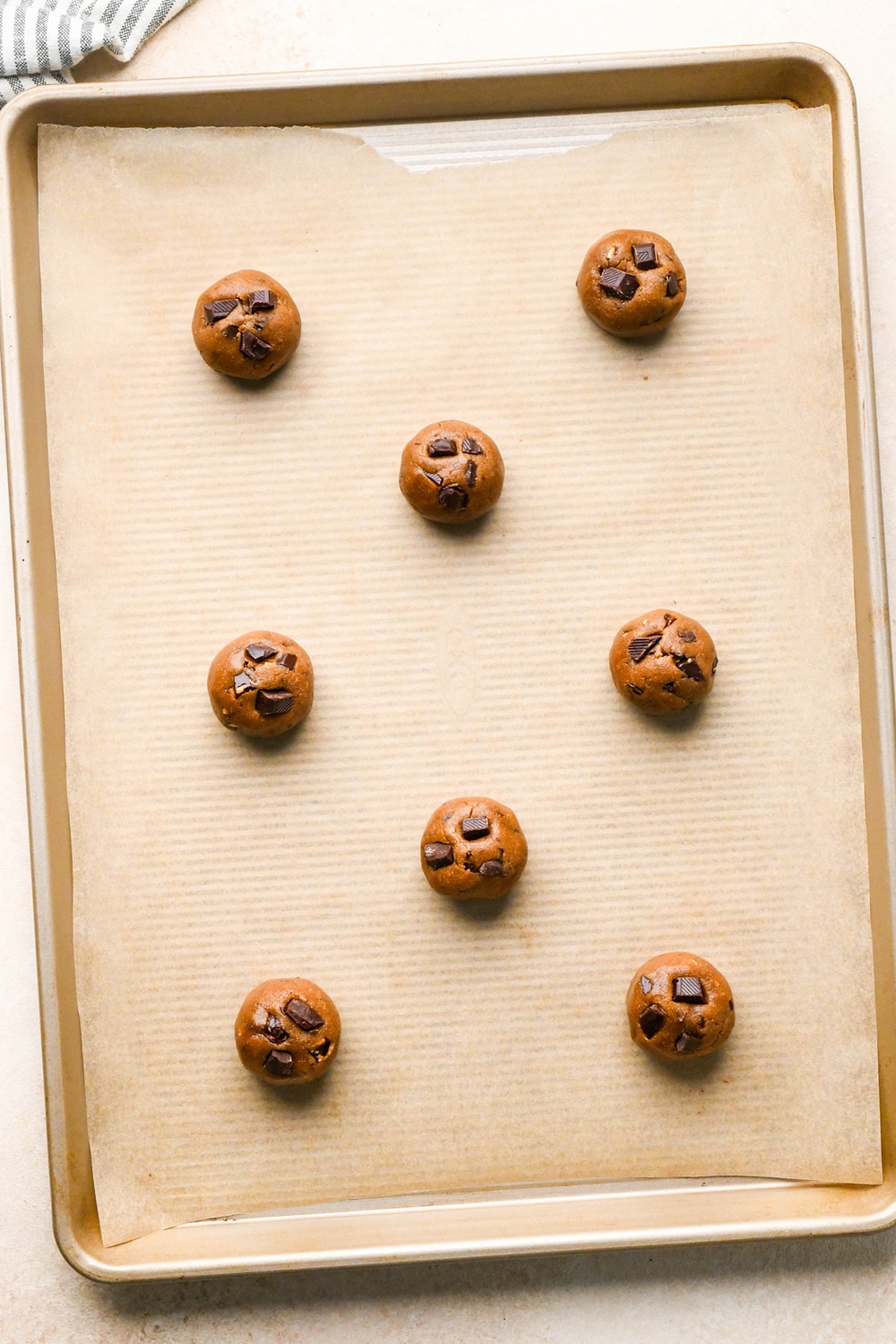 How to make Dark Chocolate Espresso Chickpea Flour Cookies: Rolled cookies evenly spaced on a baking sheet.