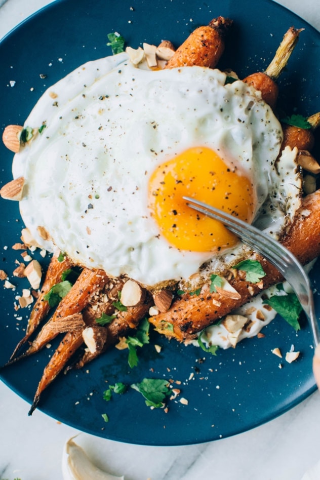 Black pepper roasted carrots with savory cilantro yogurt and roasted almonds are super easy and flavor packed to the max! The carrots are seasoned with black pepper, a little bit of paprika, and paired with a bright + savory cilantro yogurt sauce - the perfect combo! Topped with some roasted almonds to add some texture and crunch for the win!