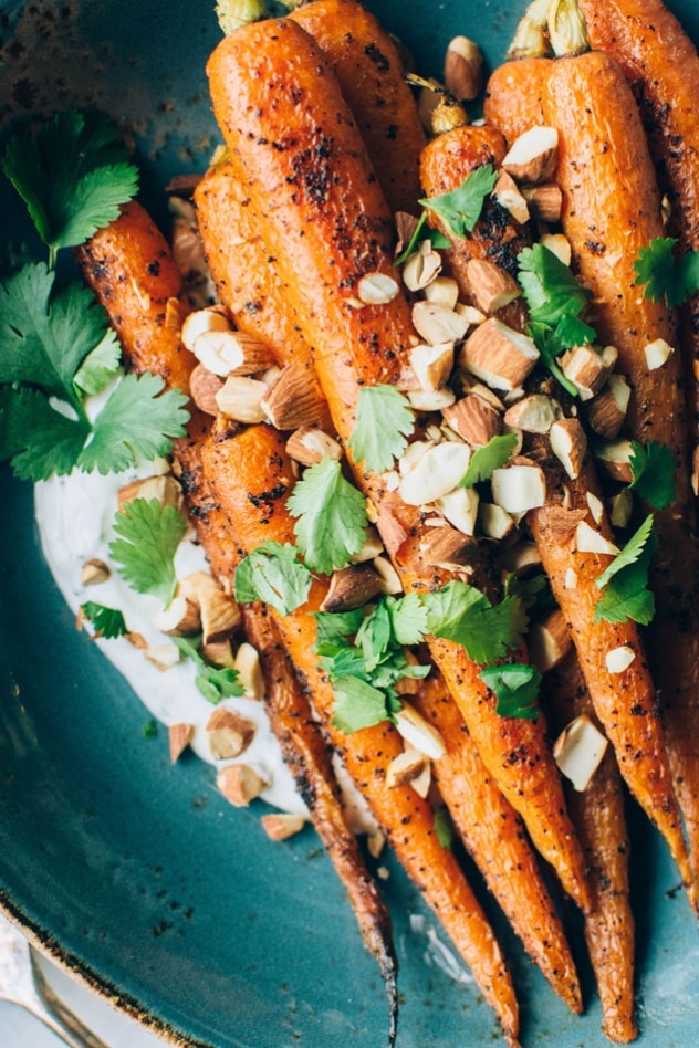 Black pepper roasted carrots with savory cilantro yogurt and roasted almonds are super easy and flavor packed to the max! The carrots are seasoned with black pepper, a little bit of paprika, and paired with a bright + savory cilantro yogurt sauce - the perfect combo! Topped with some roasted almonds to add some texture and crunch for the win!