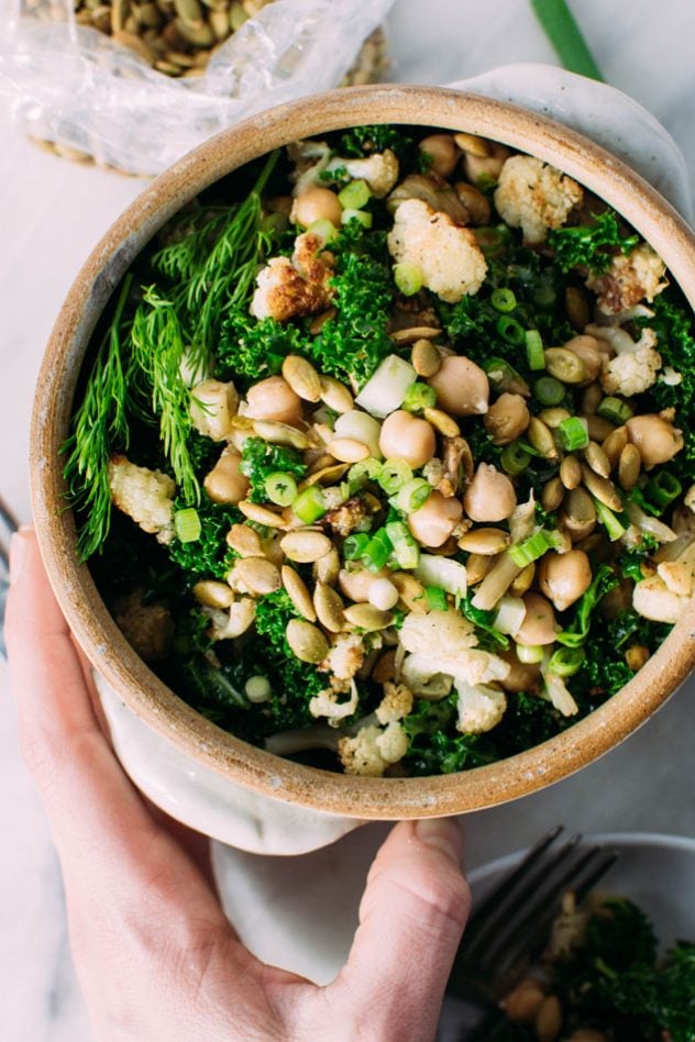 chopped winter detox salad with roasted cauliflower + chickpeas + kale! Gluten free, vegan and easily made paleo by substituting the chickpeas for some chicken or turkey, this hearty and healthy winter salad is the perfect clean salad to tuck into your fridge and enjoy all week long!