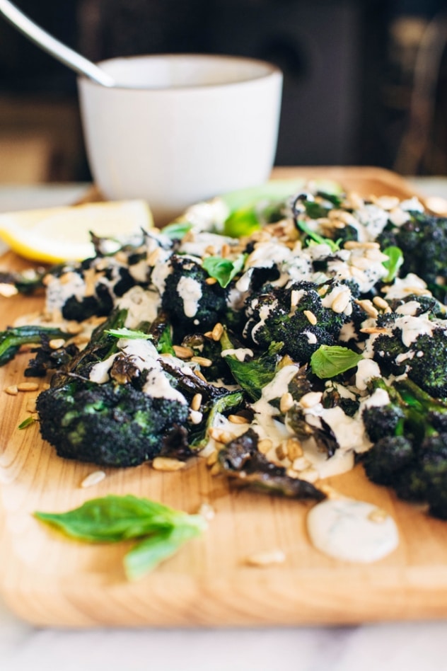 Charred purple sprouting broccoli with caper basil tahini sauce is a simple spring vegetable recipe with purple sprouting broccoli and an easy to make tahini sauce that's elevated with garlic, lemon, capers and basil, topped with some toasted sunflower seeds for crunch.