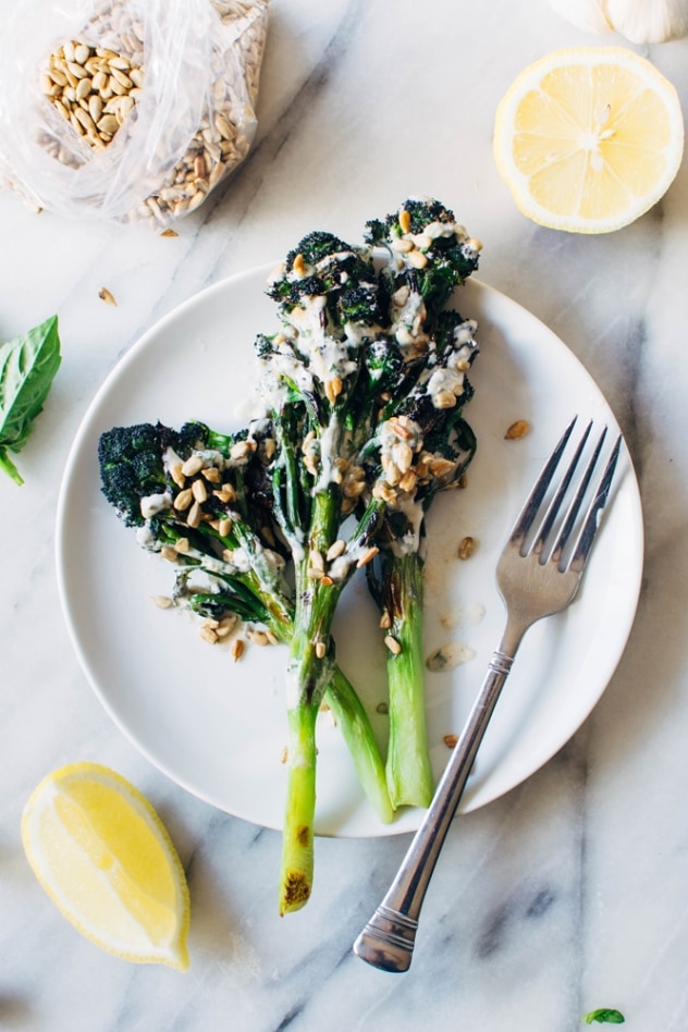 Charred purple sprouting broccoli with caper basil tahini sauce is a simple spring vegetable recipe with purple sprouting broccoli and an easy to make tahini sauce that's elevated with garlic, lemon, capers and basil, topped with some toasted sunflower seeds for crunch.