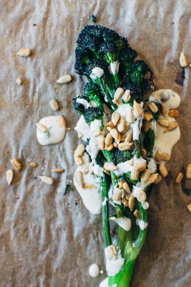 Charred purple sprouting broccoli with caper basil tahini sauce is a simple spring vegetable recipe with purple sprouting broccoli and an easy to make tahini sauce that's elevated with garlic, lemon, capers and basil, topped with some toasted sunflower seeds for crunch.