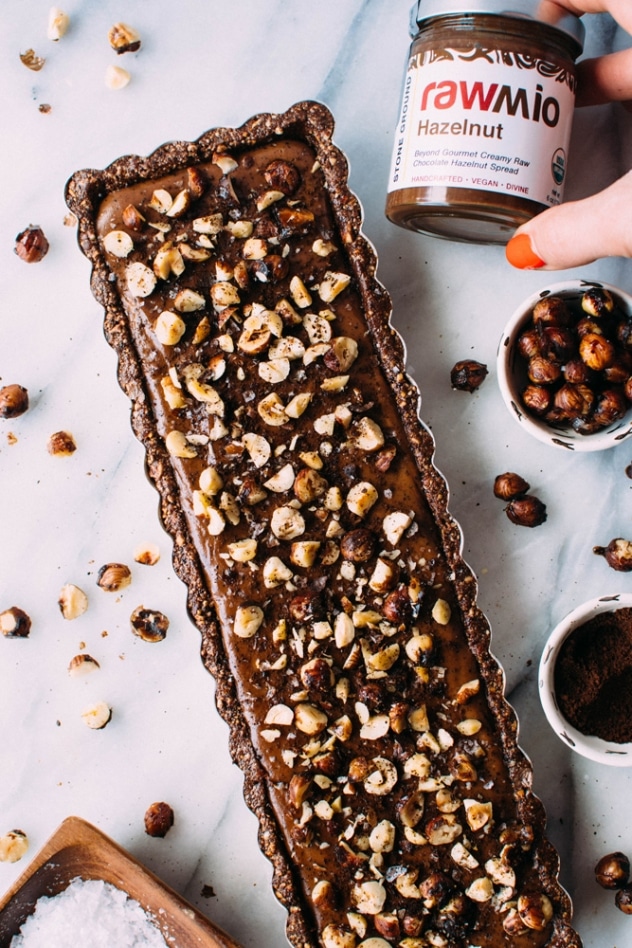 Salted mocha hazelnut tart with Rawmio chocolate is an incredibly decadent and satisfying vegan and paleo dessert! No bake, made with nutrient dense ingredients, and sprinkled with sea salt like every great chocolate dessert should be.