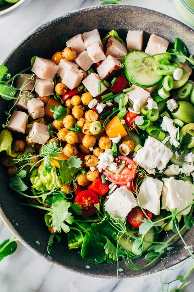 Loaded greek salad bowl with crispy chickpeas and creamy jalepeño dressing is satisfying, healthy and easy to make! Packed with crisp greens, loads of veggies, buttery casteltravano olives, crispy chickpeas and feta cheese it's a salad lovers DREAM!