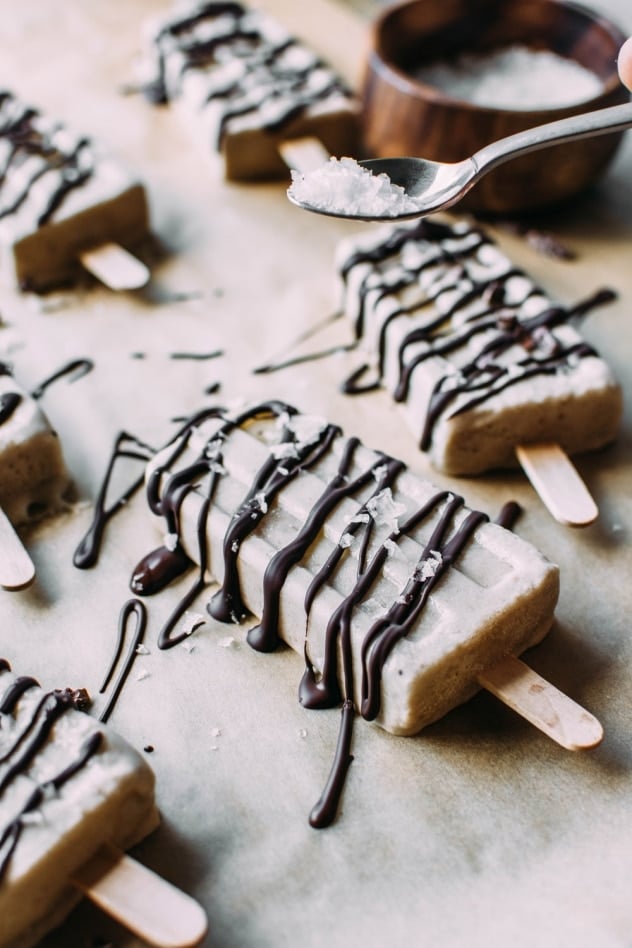 Sprinkling salt for salted banana date popsicles. An amazing paleo and vegan frozen treat that are made with a few simple and healthy ingredients!