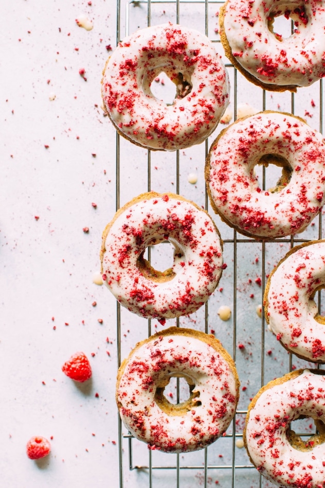 Grain free raspberry donuts with a vanilla coconut glaze! Crumbly in all the right ways, slightly springy in texture, studded with fresh raspberries, dipped in a luscious vanilla coconut glaze and sprinkled with tart dried raspberries.