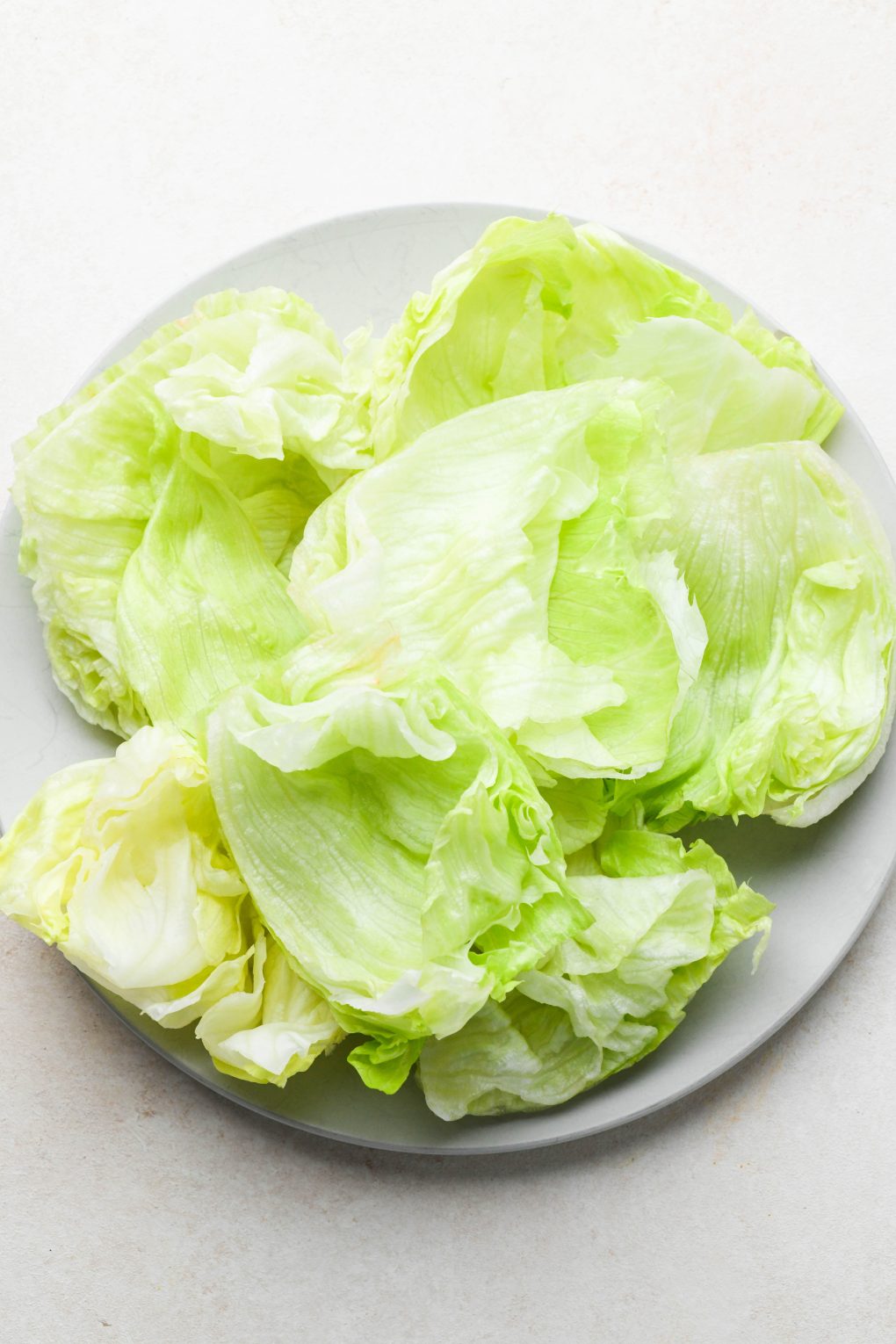 Iceberg lettuce wedges on a platter for buns in lettuce wrapped burgers.