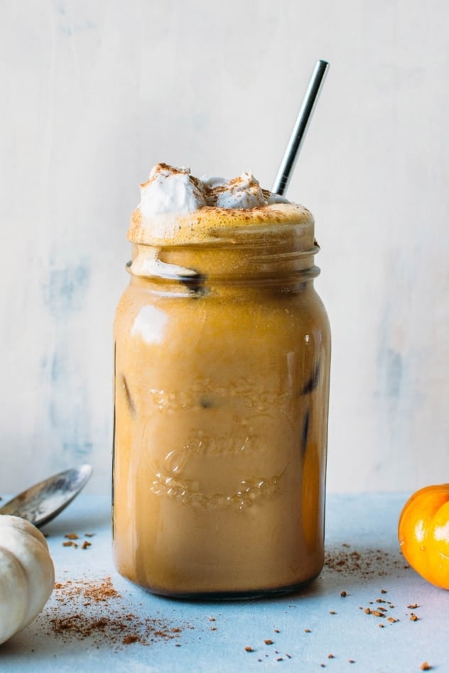 Paleo iced pumpkin spice latte - a dairy free and healthier version of everyone's favorite seasonal drink! Made with real pumpkin and sweetened with maple syrup. Top with coconut whipped cream for the ultimate treat!