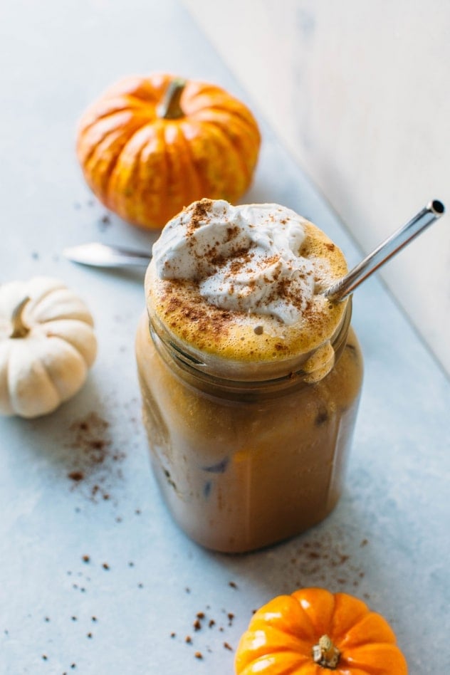 Paleo iced pumpkin spice latte - a dairy free and healthier version of everyone's favorite seasonal drink! Made with real pumpkin and sweetened with maple syrup. Top with coconut whipped cream for the ultimate treat!