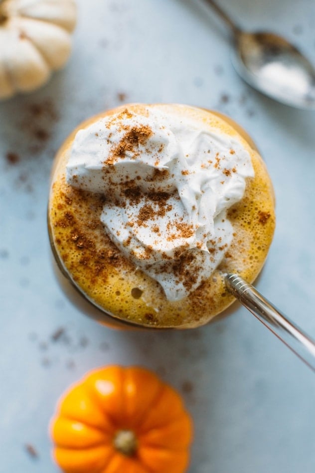 Paleo iced pumpkin spice latte - a dairy free and healthier version of everyone's favorite seasonal drink! Made with real pumpkin and sweetened with maple syrup. Top with coconut whipped cream for the ultimate treat!