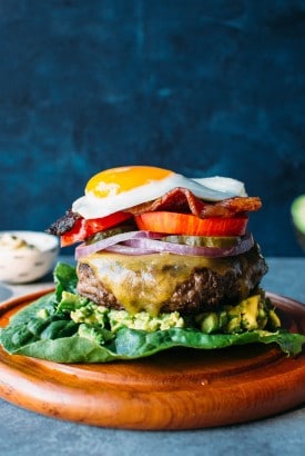 Bunless burger on romaine lettuce topped with a fried egg.