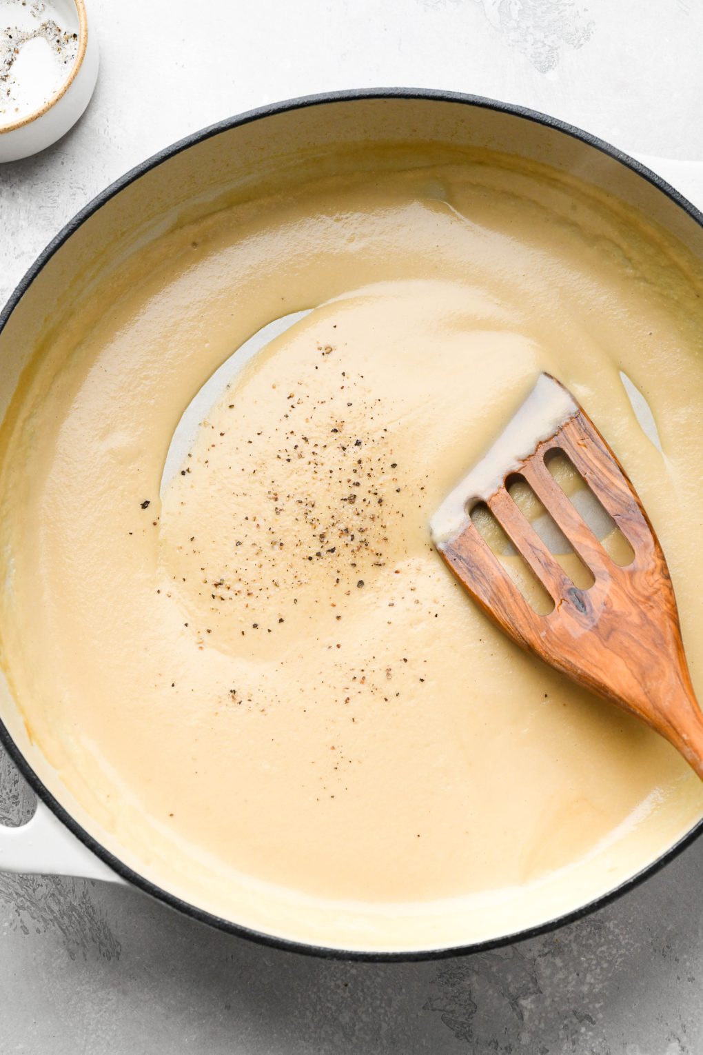 Photos showing how to make Whole30 gravy - Blended gravy back in the skillet, seasoned with salt and pepper. 
