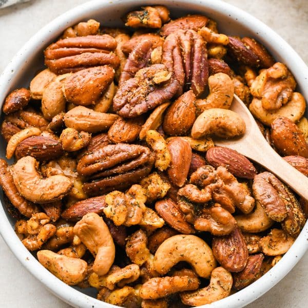 A small shallow bowl filled with herb spiced roasted nuts.