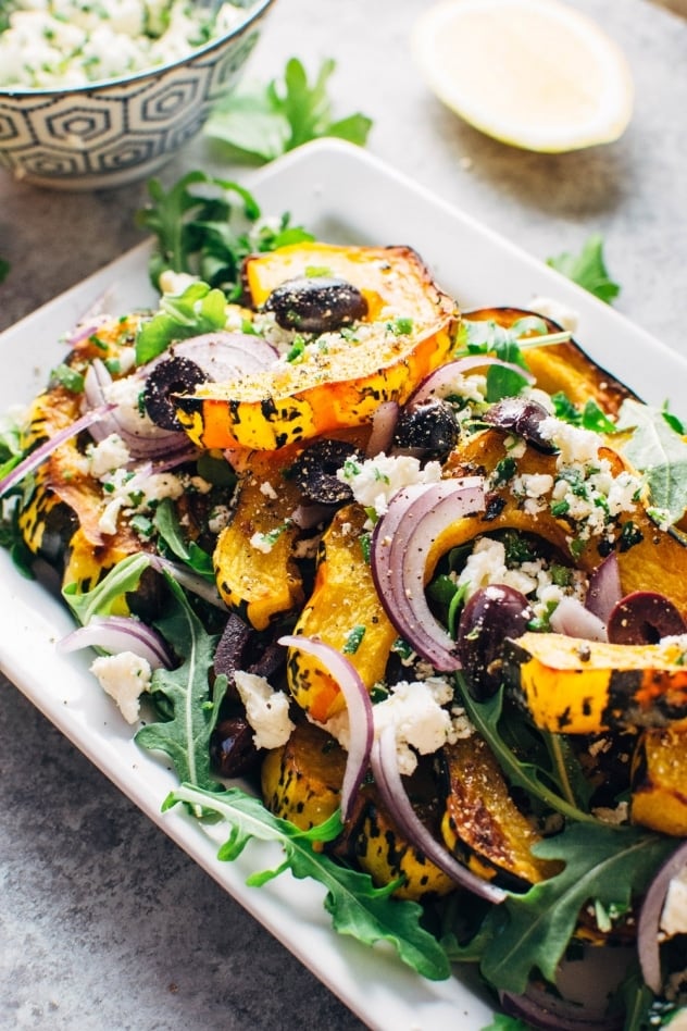 This roasted squash and arugula greek salad is made with maple chili roasted winter squash, peppery arugula and is loaded up with fresh herbs, kalamata olives, red onion and feta cheese. So much flavor and veggies make this a winning flavor bomb of a salad! 