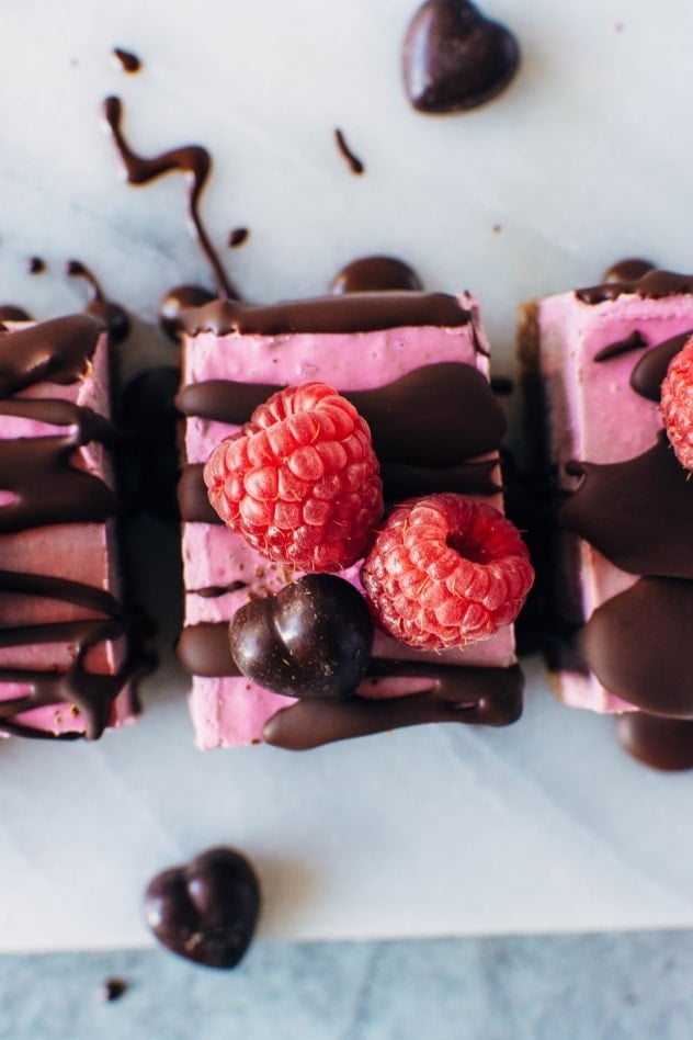 These Raspberry Chocolate No Bake Superfood Cheesecake Bars with Rawmio Chocolate are dairy free, gluten free, and refined sugar free! They're also loaded up with superfoods, healthy fats and fresh fruit! Crave worthy and good for you, they're perfect for anyone you wanna show some love on Valentine's day, or any other day of the year! 