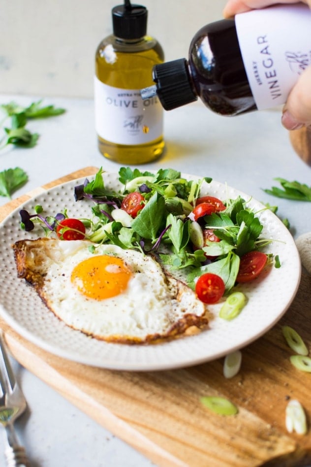 These olive oil fried eggs with a fresh herb and tomato salad are made with only a few ingredients and are legit a delightful dream of a real food breakfast! Or lunch, or dinner, if you're the kind of person who could eat fried eggs for every meal #totallyme.