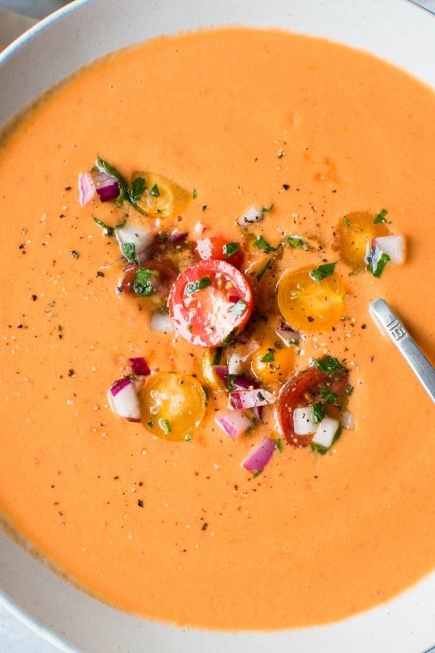 This ultimate summer gazpacho recipe is everything you could ever want from gazpacho. Bursting with flavor and full of wholesome ingredients. It is the perfect chilled summertime soup that highlights the best produce of the season. Super ripe heirloom tomatoes make it notably special, and a variety of other in-season vegetables like cucumber, peppers and red onions add an impressive depth of flavor. Plus - this version is made without bread! Which makes it paleo, vegan, and whole30 friendly! It is a summer dream come true. 
