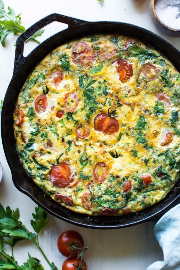 This late summer frittata with tomatoes and fresh herbs has been my go-to egg dish pretty much since it's been warm enough to wear sandals! Made with good-for-you pasture raised eggs, ripe summer tomatoes, savory caramelized shallots, spinach, and fresh parsley for some seriously delicious flavor - it's a must try!