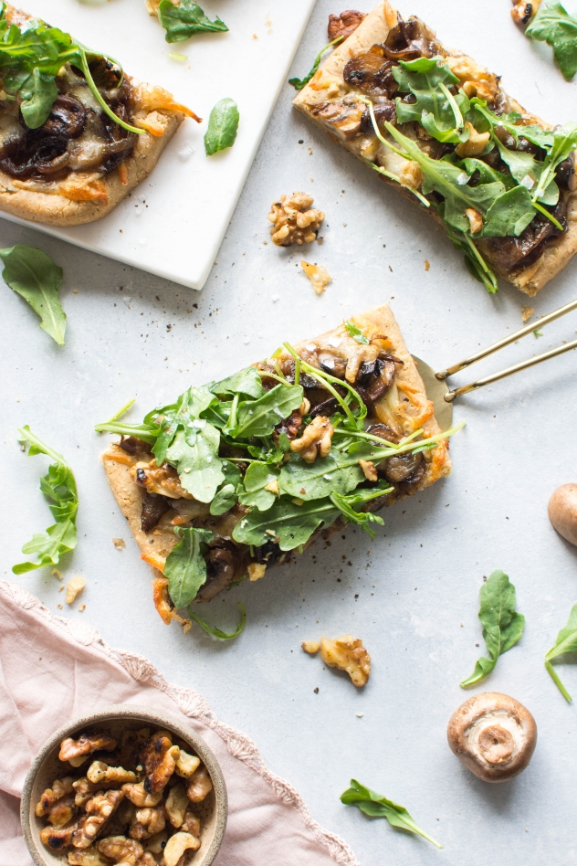 This grain free caramelized onion and mushroom pizza with arugula is made with Simple Mills almond flour pizza dough, topped with flavorful caramelized onions and mushrooms, smoked mozzarella cheese, and a peppery + bright arugula and toasted walnut salad - basically making it the ideal healthy pizza situation! 