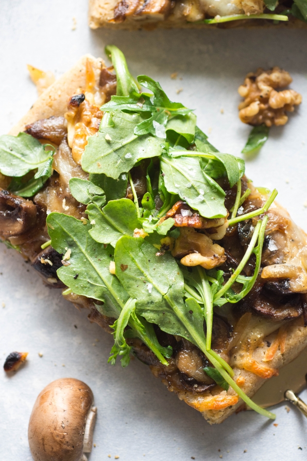 This grain free caramelized onion and mushroom pizza with arugula is made with Simple Mills almond flour pizza dough, topped with flavorful caramelized onions and mushrooms, smoked mozzarella cheese, and a peppery + bright arugula and toasted walnut salad - basically making it the ideal healthy pizza situation! 
