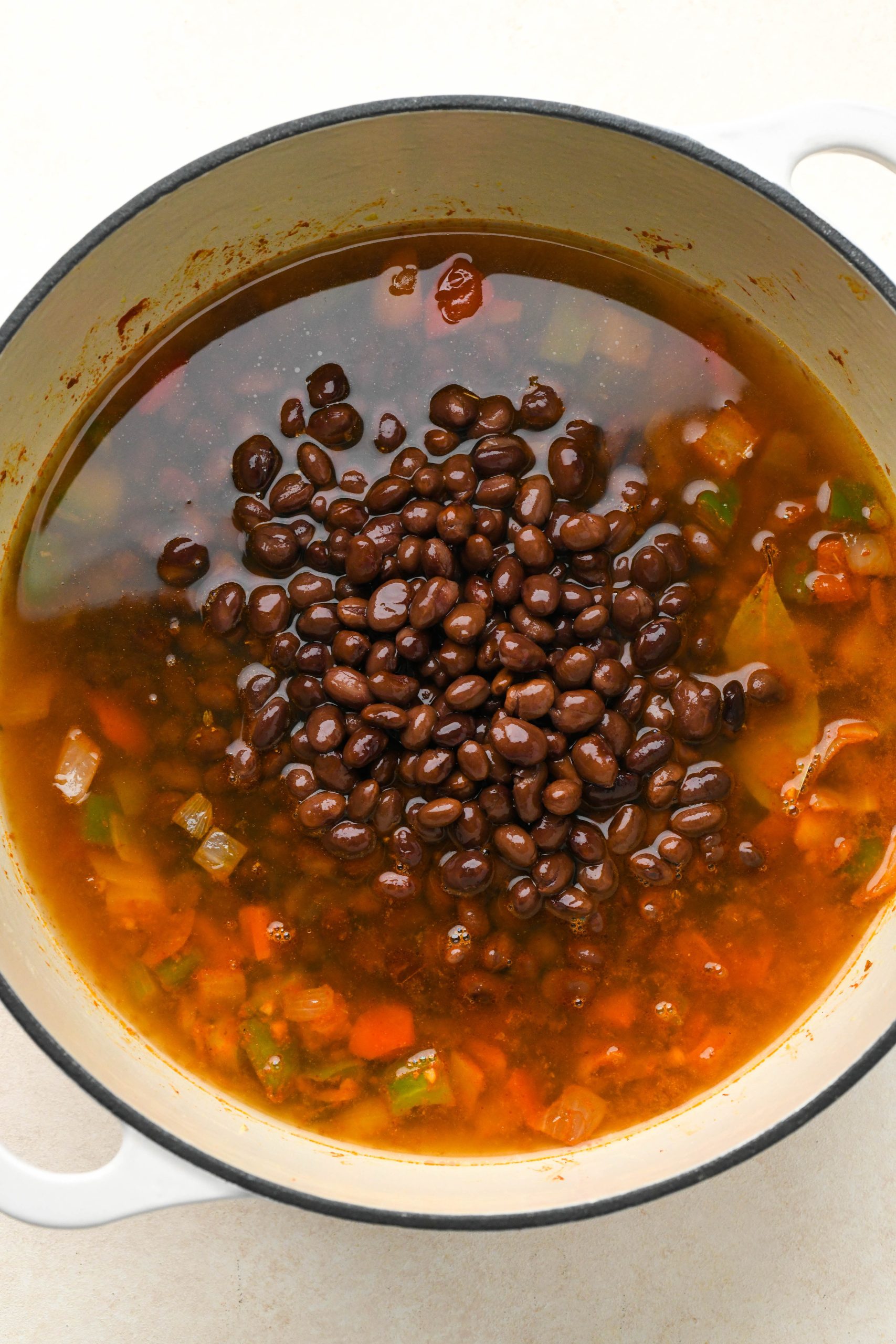 How to make vegan black bean soup: Broth and black beans added to soup pot.