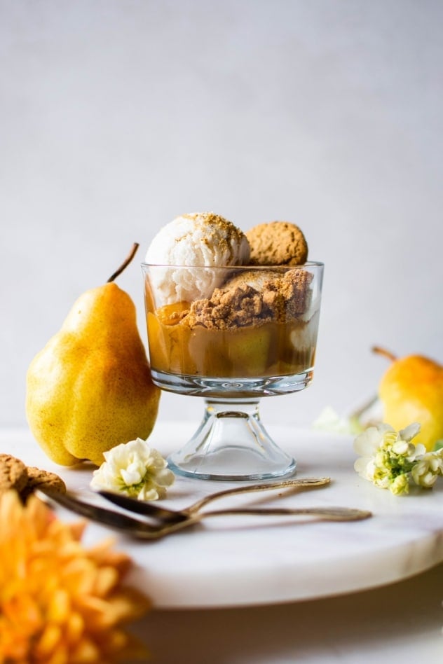 These cardamom caramel and pear cookie crumble cups are made with fragrant pears simmered in a cardamom and cinnamon spiced coconut sugar caramel. Served with your favorite dairy free vanilla ice cream and Simple Mills crunchy toasted pecan cookies. A crazy delicious seasonal dessert that is naturally sweetened, vegan and paleo friendly!