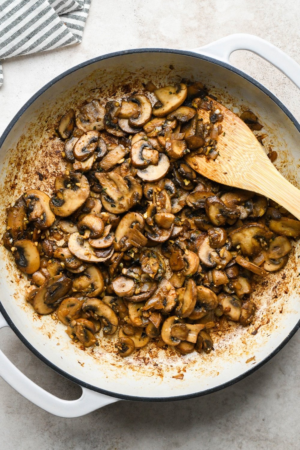 How to make Gluten Free Mushroom Gravy: Spices and aromatics being stirred into sautéed mushrooms.