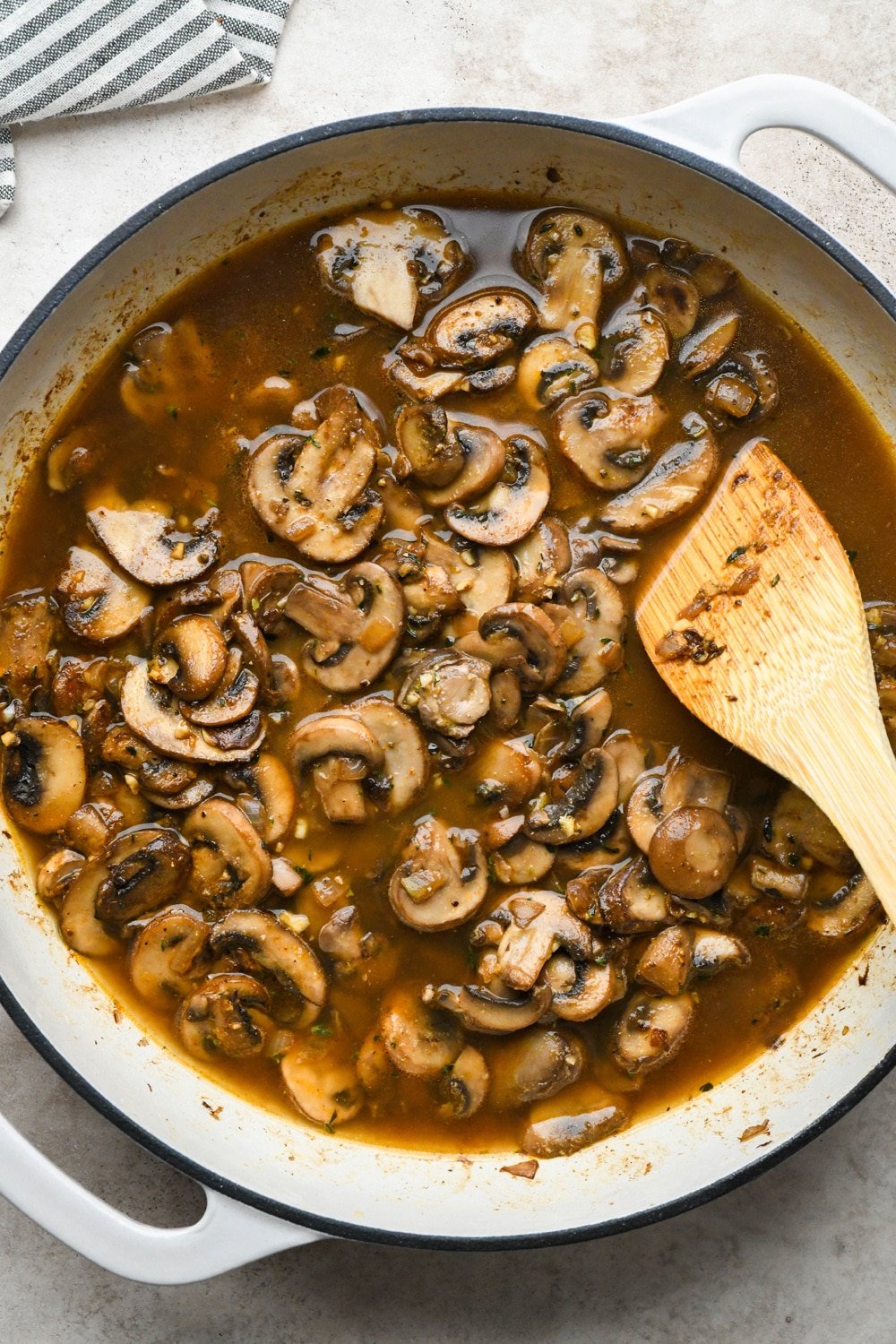 How to make Gluten Free Mushroom Gravy: Mushroom broth simmering with mushrooms in large skillet.