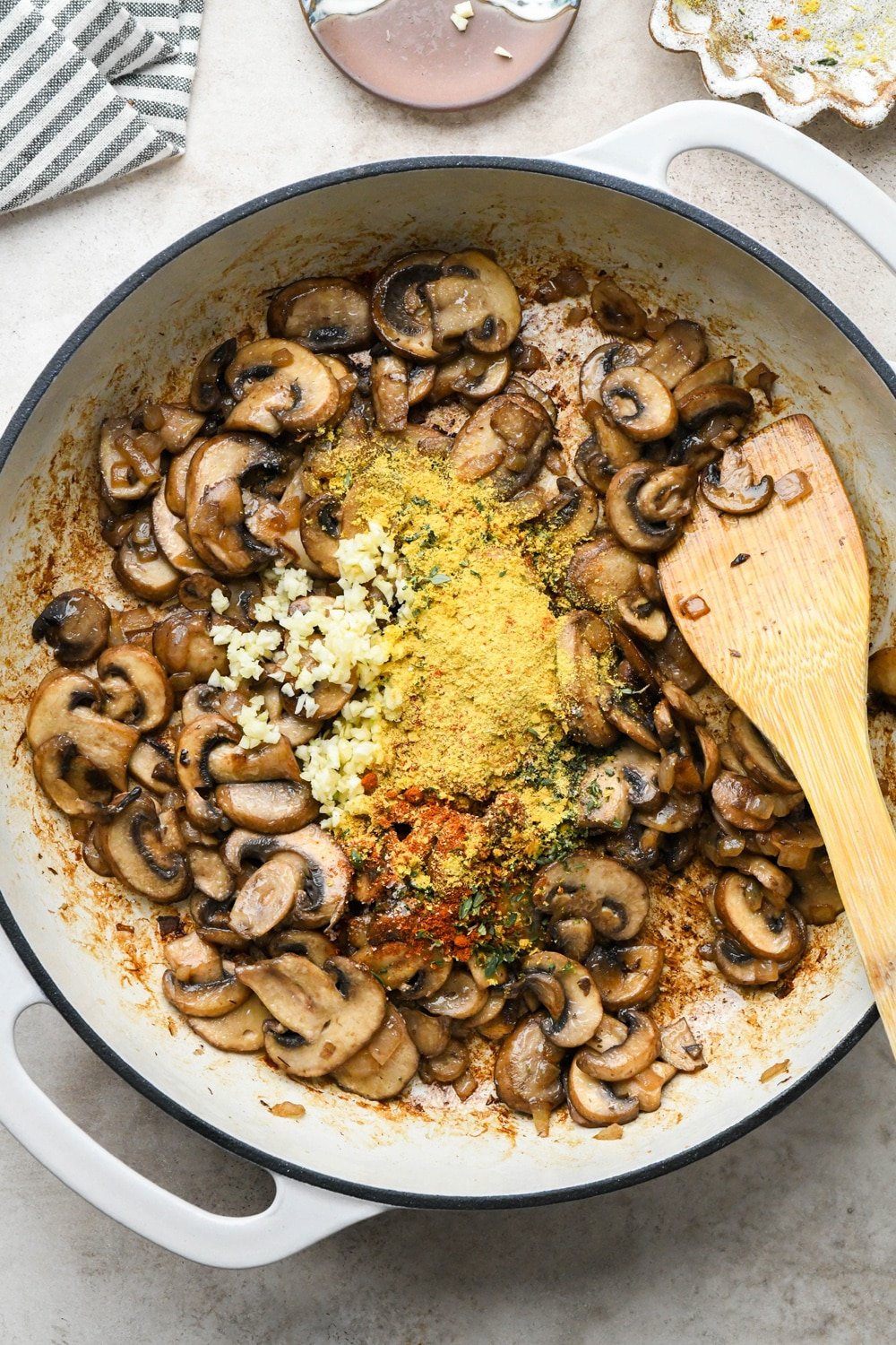 How to make Gluten Free Mushroom Gravy: Spices, aromatics, and garlic in skillet with sautéed mushrooms.