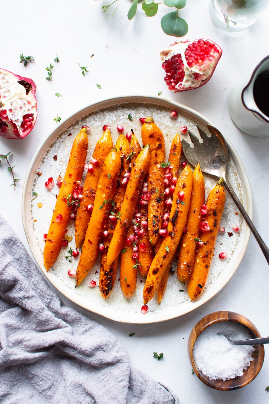 Maple chili roasted carrots topped with fresh thyme and pomegranate.