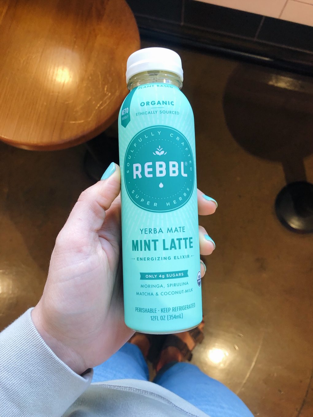 Holding a Chocolate mint Rebbl drink in the grocery store