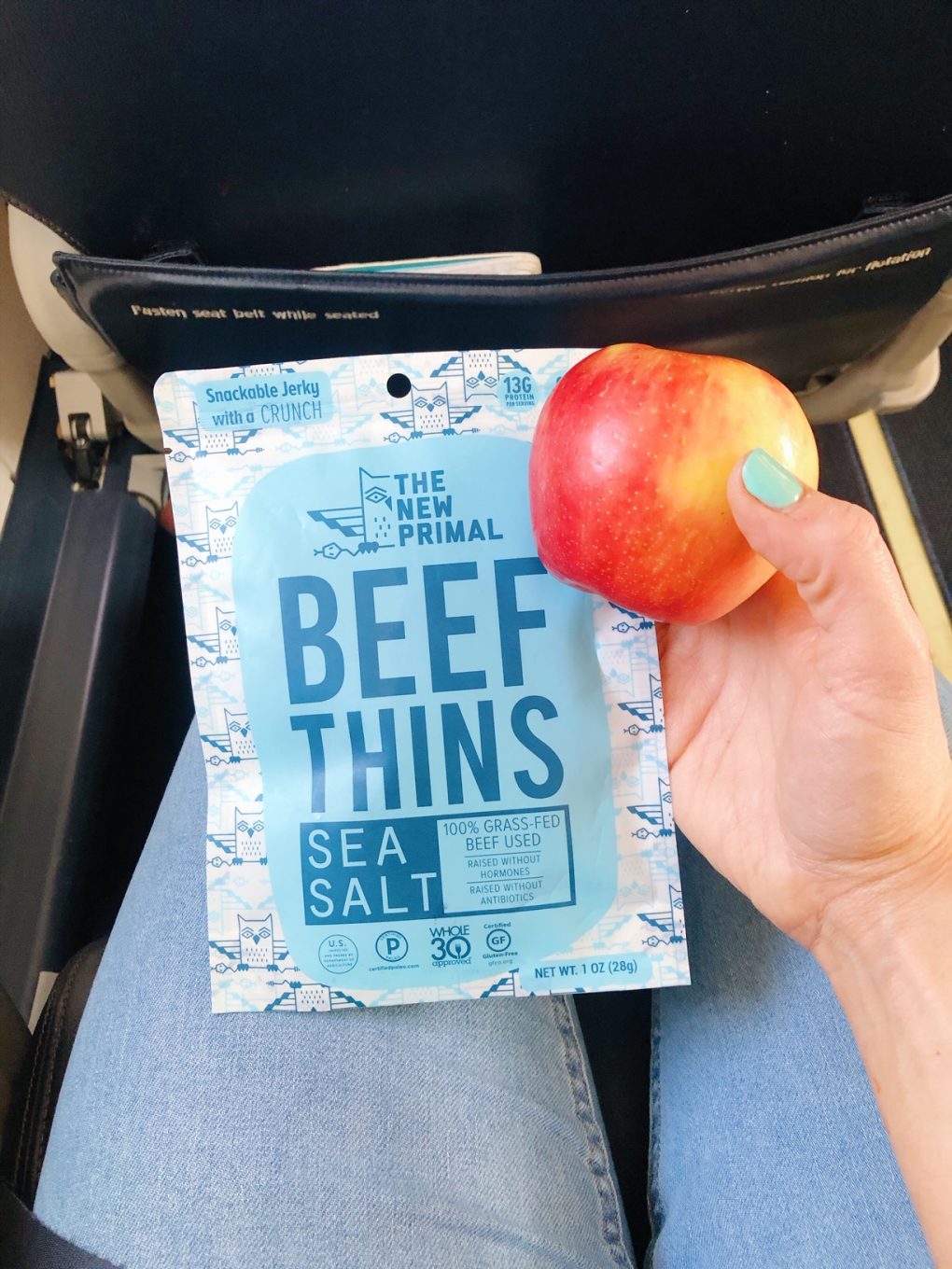 Holding a bag of the new primal beef thin snacks and an apple in my lap on an airplane