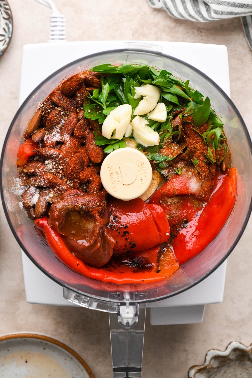 How to make Dairy Free Romesco Sauce: All ingredients in the container of a food processor before pulsing to combine.