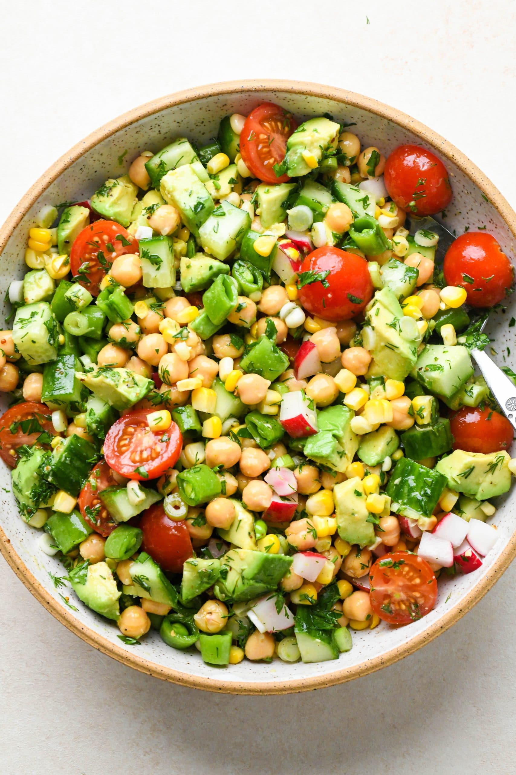 How to make vegan chickpea salad: Salad tossed together in a large bowl.
