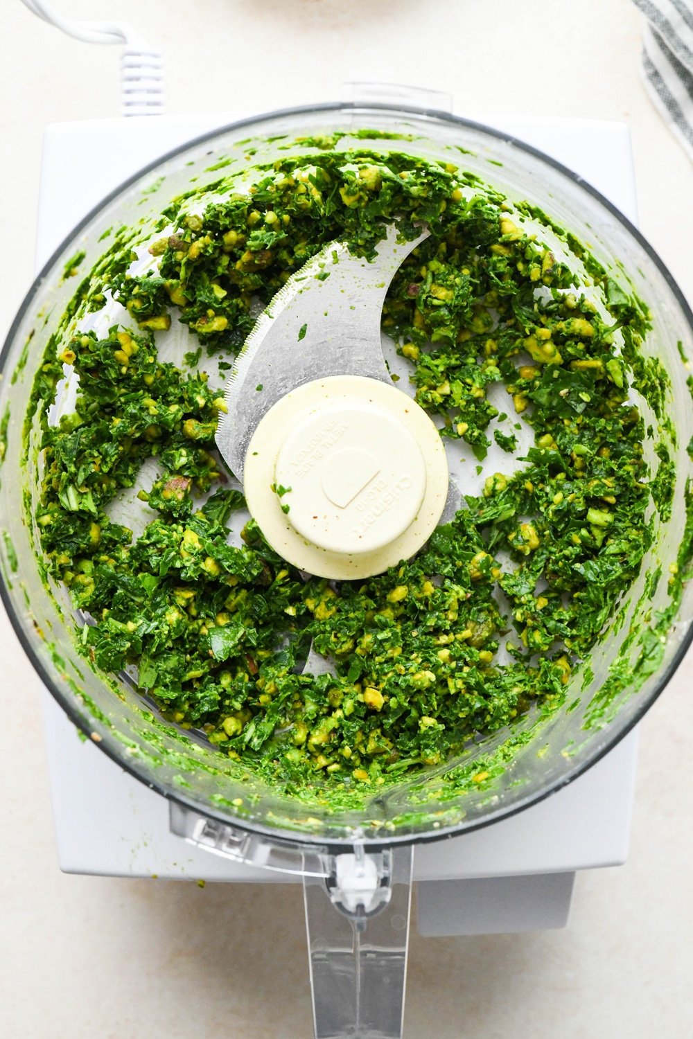 How to make pistachio pesto: Dry ingredients in the container of a food processor after pulsing together. 