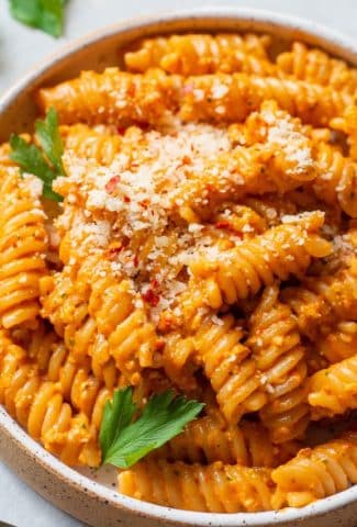 Close up shot of a shallow bowl of romesco pasta with gluten free noodles.