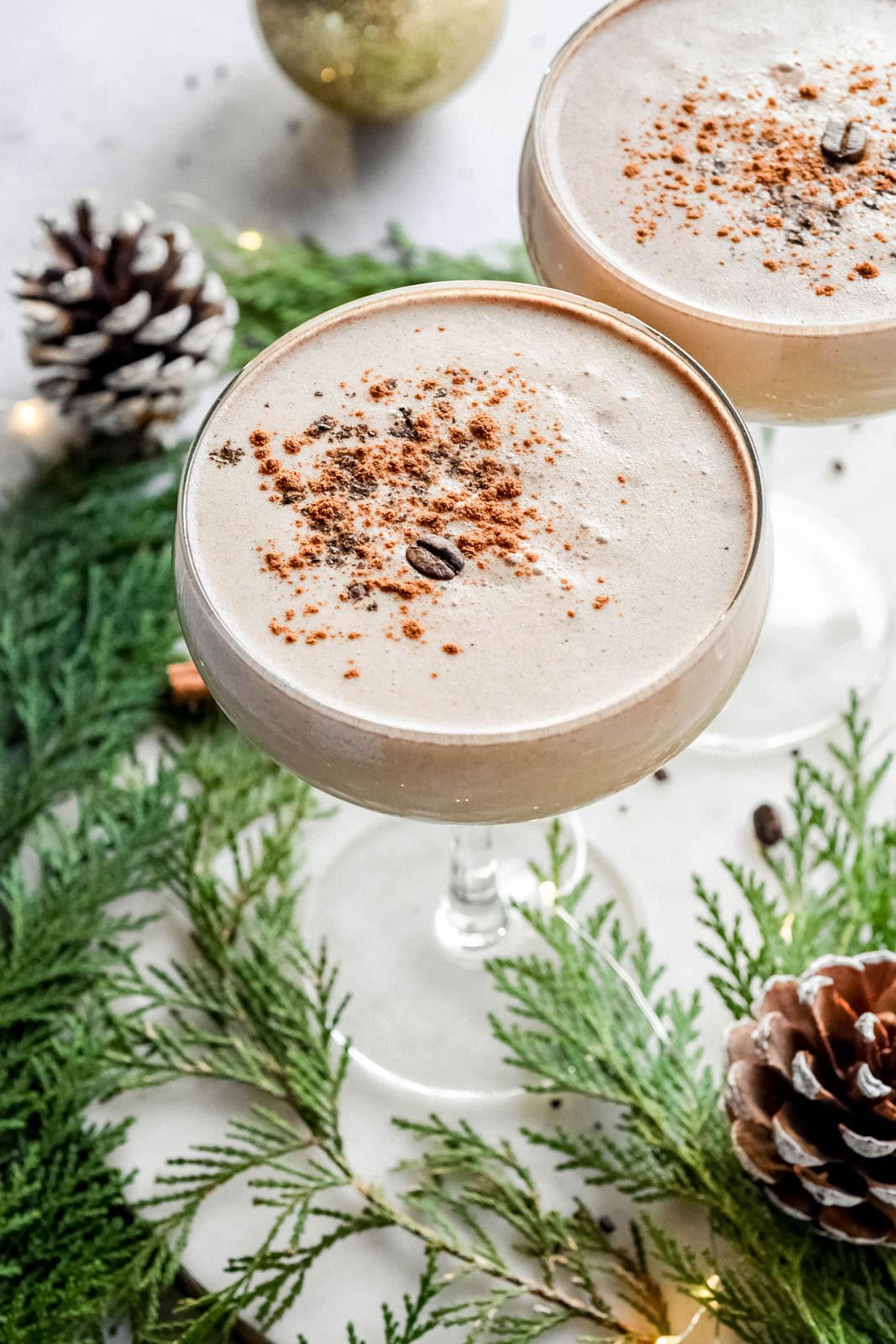 This eggnog espresso martini with rum is a luscious and festive homemade holiday cocktail. Made with your favorite eggnog, rum (or whiskey or vodka!), coffee liqueur, cold brew coffee or espresso, vanilla, and cinnamon. The perfect eggnog martini recipe to enjoy during the holiday season! Easily made dairy free by using a plant based (vegan) eggnog. #eggnog #holidays #homebartending #christmas #cocktail