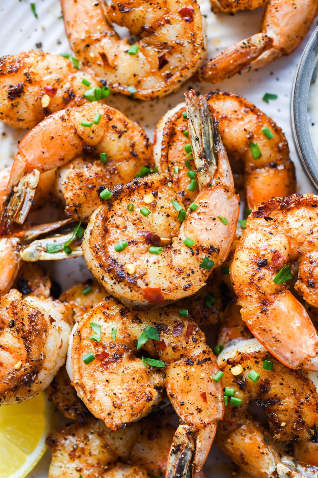 Close up shot of whole30 cajun spiced shrimp topped with snipped chives.